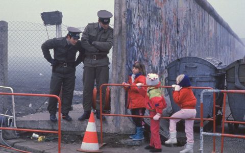 1989年。柏林，西德小朋友隔着墙和东德警官交谈 ​​​​